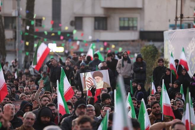 이란의 수도 테헤란의 한 광장에서 추모객들이 모여 아야톨라 세예드 알리 하메네이 이란 최고지도자의 사진을 들고 거리 시위에 나선 모습. [EPA, 연합뉴스]