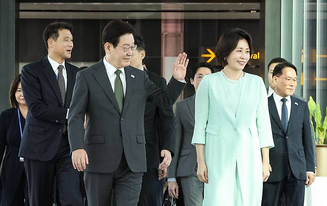 싱가포르 국빈방문을 마친 이재명 대통령과 김혜경 여사가 3일 창이 국제공항에서 다음 순방지인 필리핀 마닐라로 향하는 공군 1호기로 이동하며 공항직원들에게 인사하고 있다. [연합]
