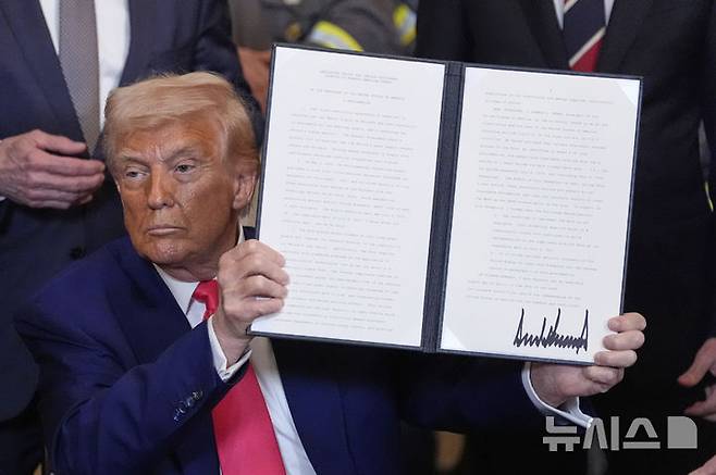[워싱턴=AP/뉴시스] 도널드 트럼프 미국 대통령이 2025년 4월8일 백악관 이스트룸에서 석탄 산업 활성화 행정명령에 서명한 후 이를 들어 보이고 있다. 트럼프 행정부가 2일 여러 로펌들을 제재하는 도널드 트럼프 대통령의 행정명령을 옹호하던 입장을 철회했다고 월 스트리트 저널(WSJ)이 이날 보도했다. 이로써 법조계를 뒤흔들고, 법조계 지도자들이 백악관에 맞설 것인지, 굴복할 것인지 선택해야 했던 지난 1년 간의 혼란에 마침표를 찍게  됐다. 2026.03.03.