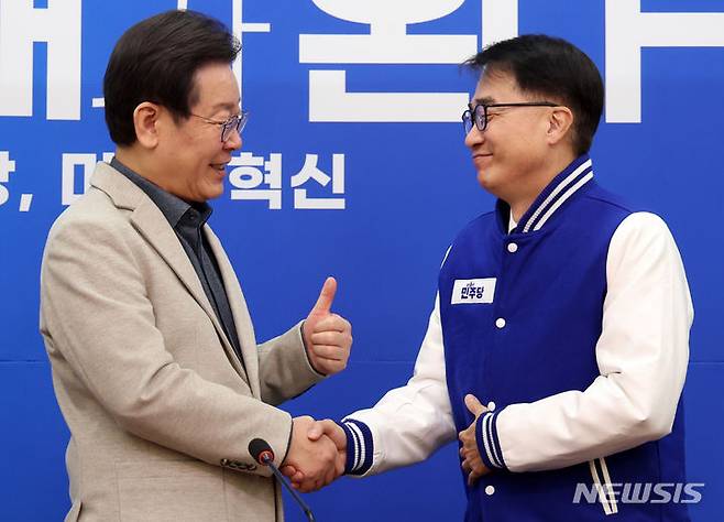 [서울=뉴시스] 이영환 기자 = 이재명 더불어민주당 대표가 2024년 2월16일 오전 서울 여의도 국회에서 열린 인재환영식에서 김준환 전 국가정보원 차장에게 당 점퍼를 입혀준 후 악수를 하고 있다. 2024.02.16. 20hwan@newsis.com