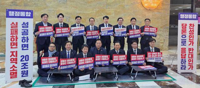 더불어민주당 정청래 대표와 한병도 원내대표가 27일 국회 로텐더홀에서 충남·대전 행정통합을 촉구하며 국민의힘을 규탄하는 민주당 충남·대전 의원들의 농성장을 방문해 손팻말을 들고 있다. 연합뉴스