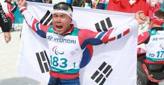 대한민국 신의현이 17일 오후 강원도 평창 바이애슬론센터에서 열린 2018 평창동계패럴림픽 크로스컨트리스키 남자 7.5㎞ 좌식 경기에서 금메달을 차지한 뒤 태극기를 들고 포효하고 있다. IS포토