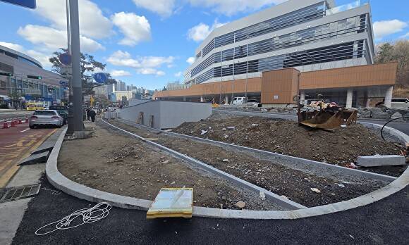 지난 3일 동백종합복지회관 공사 현장 앞 보행로가 있지만 차량들이 주차돼 있어 시민들이 흙길로 이동하고 있다. [사진=정재수 기자]