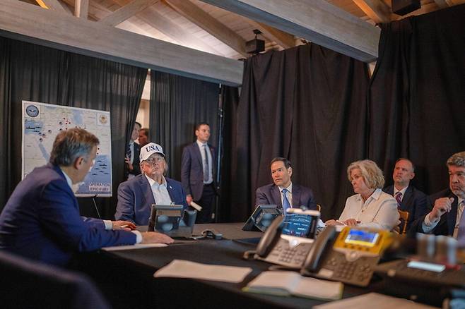 ‘USA’가 새겨진 흰색 모자를 쓴 도널드 트럼프 미국 대통령(왼쪽 둘째)이 지난달 28일(현지시간) 플로리다주 마러라고 사저에 마련된 임시 상황실에서 마코 루비오 국무장관(왼쪽 셋째), 수지 와일스 백악관 비서실장과 ‘거대한 분노’ 작전 상황을 점검하고 있다. < 출처 : 연합뉴스 >