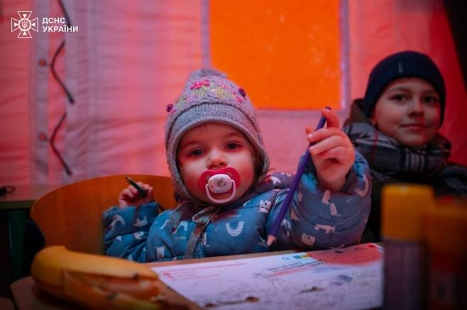 11일(현지시간) 우크라이나 비상사태청은 수도 키이우 아파트 단지 내에 한국이 지원한 발전기를 설치했다고 밝혔다. 앞서 박기창 주우크라이나 대사는 지난해 8월 우크라이나 비상사태청을 방문해 수송버스 3대와 중소형 발전기 100대를 전달한 바 있다. 한국국제협력단(KOICA)와 유엔사업서비스기구(UNOPS)의 지원으로 이뤄진 기증 행사에 앞서 우크라이나 측은 최전선에서 구조 활동 중 파손된 장비들을 보여주며 인도주의적 지원의 중요성을 강조했다. 사진은 전력 공급이 끊긴 키이우 아파트 단지 내 난방대피소 내부. 2026.1.11 우크라 비상사태청