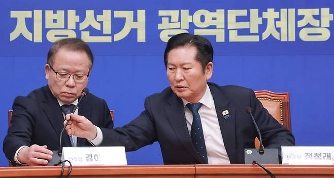 더불어민주당 정청래 대표가 5일 국회에서 열린 중앙당 공천관리위원회 지방선거 후보 공천 심사 결과 발표 회견에서 김이수 공관위원장 발언에 앞서 마이크 세팅을 돕고 있다. 연합뉴스