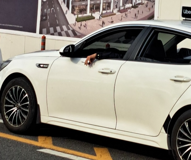 지난 5일 오전 울산역으로 진입하던 한 택시에서 기사가 담배를 피우고 있다.