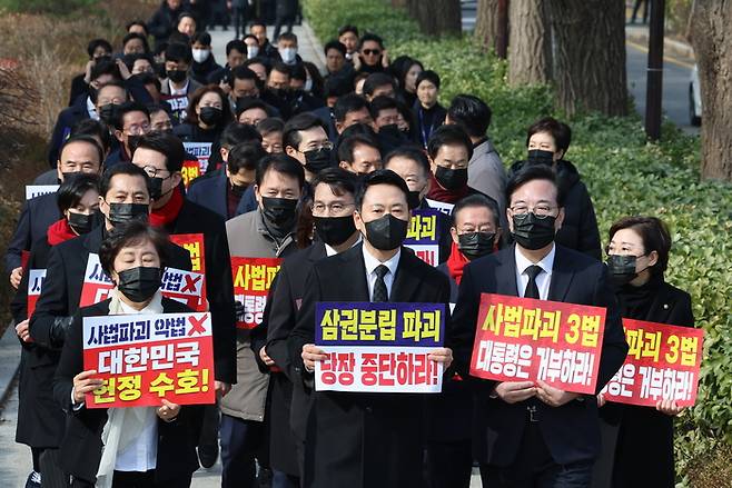 장동혁 대표와 송언석 원내대표를 비롯한 국민의힘 의원들이 5일 청와대 분수대 앞에서 의원총회를 마친 뒤 손팻말을 들고 청와대 방향으로 이동하고 있다. [연합뉴스]