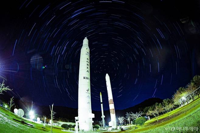 한국형 발사체 누리호 4차 발사가 성공하며 민간이 제작·조립을 맡은 발사체가 처음으로 정상 임무를 수행했다.   누리호 4차 발사는 한국형 발사체 최초의 야간비행이자 역대 최다인 13기의 위성이 탑재됐다. 나로우주센터 우주과학관 로켓광장에 우리나라에서 개발된 1단형 고체추진 로켓 KSR-Ⅰ, 2단형 고체추진로켓 KSR-Ⅱ, 액체추진 과학로켓 KSR-Ⅲ, 우주발사체 KSLV-Ⅰ(나로호)의 실물크기 로켓 모형 뒤로 별의 일주운동 궤적이 보이는 모습. (별의 일주운동 궤적은 30초로 2시간 촬영 후 각각의 사진 레이어 합성) 2025.12.30./사진=뉴시스