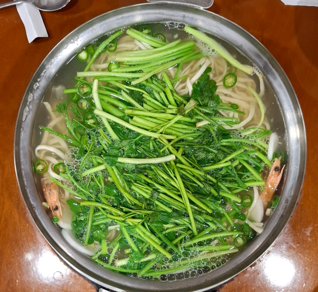 미나리를 얹은 복칼국수.