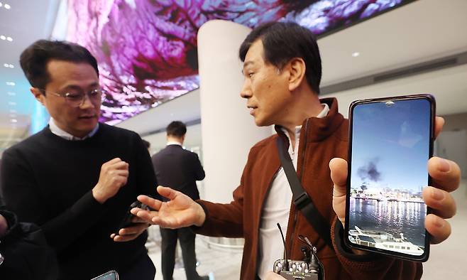 직접 찍은 폭격 사진 중동을 방문했다 귀국한 한 여행객이 5일 인천국제공항에서 현지에서 찍은 사진을 보여주며 취재진과 인터뷰하고 있다. 인천공항=연합뉴스