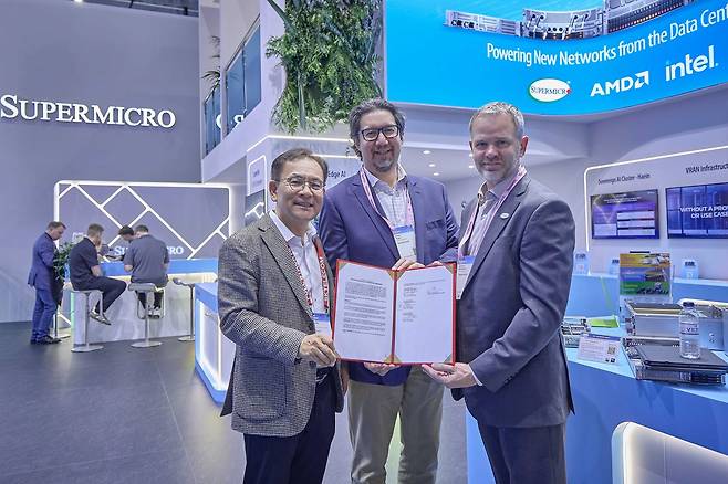 MWC26 슈퍼마이크로 전시관에서 기념 촬영 중인 (왼쪽부터) 하민용 SKT AI DC 사업 담당, 앤드류 브래드너 슈나이더 일렉트릭 수석 부사장, 클레이 시먼스 슈퍼마이크로 부사장의 모습.