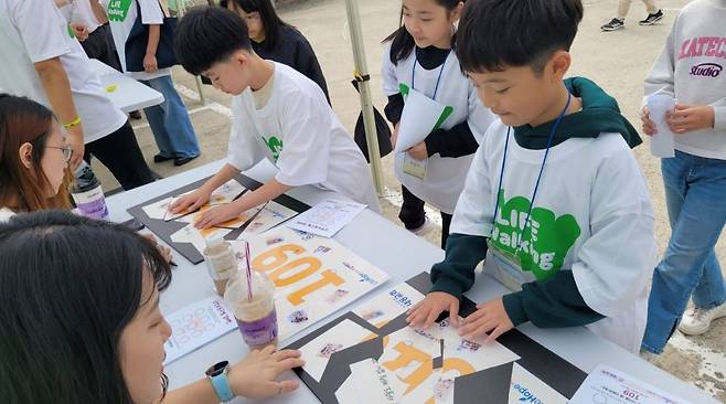 부천 내동감리교회가 주차장을 비우고 마련한 캠페인 부스에서 동네 아이들이 자살예방 상담 번호 '109' 퍼즐을 맞추고 있다. 라이프호프 제공