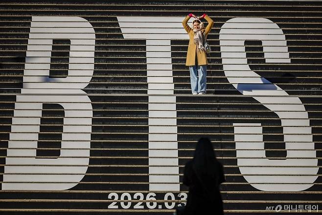 [서울=뉴시스] 정병혁 기자 = 20일 서울 종로구 세종문화회관 계단을 찾은 외국인 여행객들이 방탄소년단(BTS) 래핑을 배경으로 사진을 찍고 있다.  외국인의 한국에 대한 호감도가 2018년 조사 이래 가장 높은 82.3%로 나타났다. '2025년도 대한민국 국가이미지 조사 결과'에 따르면 외국인의 한국에 대한 호감도는 전년(79.0%) 대비 3.3%p 상승한 82.3%로, 2018년 조사를 시작한 이래 최고 수준을 기록했다. 호감도가 80%를 넘은 것은 2021년(80.5%) 이후 두 번째이자 4년 만이다. 2026.01.20./사진=정병혁