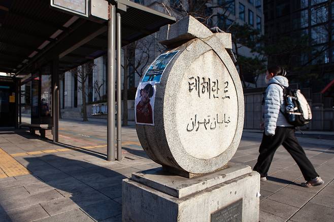 Photos of people killed during the protests that rocked Iran earlier this year can be seen on the left side of the Teheran-ro street marker in Gangnam District, southern Seoul, on March 8. [MICHAEL LEE]