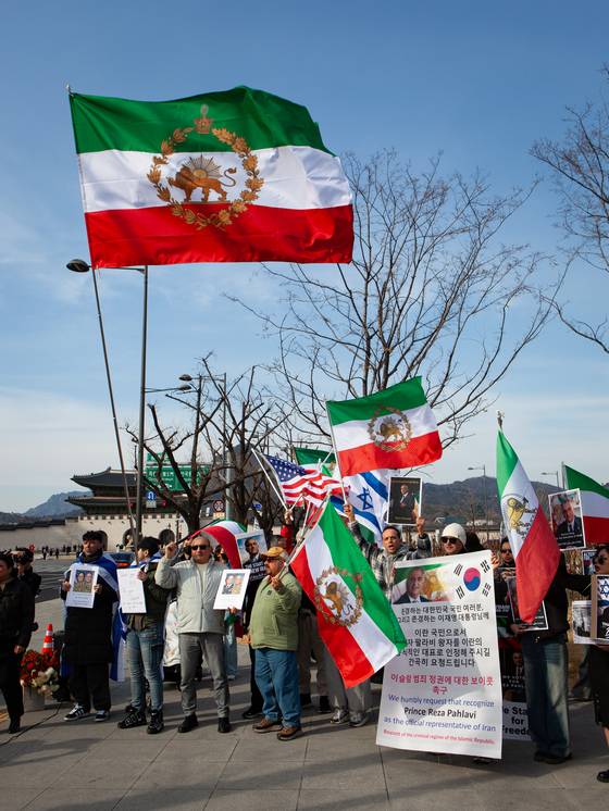 Iranian residents of South Korea wave banners based on the design of Iran's prerevolutionary flag as they call for the restoration of Reza Pahlavi, the son of the last Shah Mohammad Reza Pahlavi, as their country's monarch during a rally in Gwanghwamun Square, central Seoul, on March 8. [MICHAEL LEE]