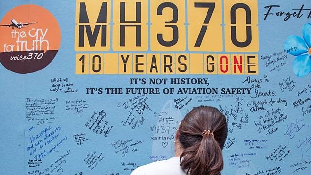 2024년 3월 말레이시아 쿠알라룸프르에서 열린 말레이시아 항공 MH370편 실종 10년 추모 행사에서 한 시민이 벽에 적힌 글귀를 읽고 있는 모습./사진=AFP=뉴스1