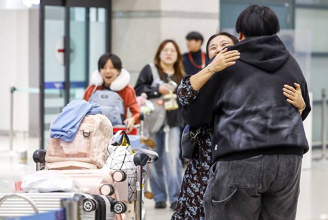 중동 상황 악화로 정부가 전세기를 투입한 가운데 9일 새벽 아부다비를 출발한 정부 전세기 탑승객들이 인천국제공항 1터미널을 통해 귀국하며 가족을 만나고 있다.뉴시스