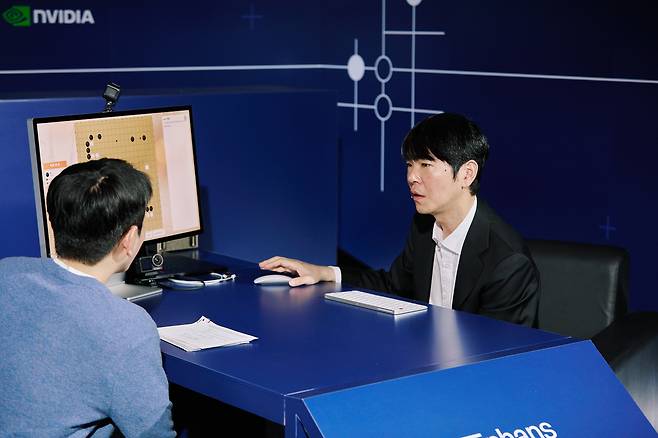 Lee Se-dol (right) tests a Go application during an Enhans AI demonstration at Seoul’s Four Seasons Hotel on Monday, ten years after he faced AlphaGo at the same venue. (Enhans)