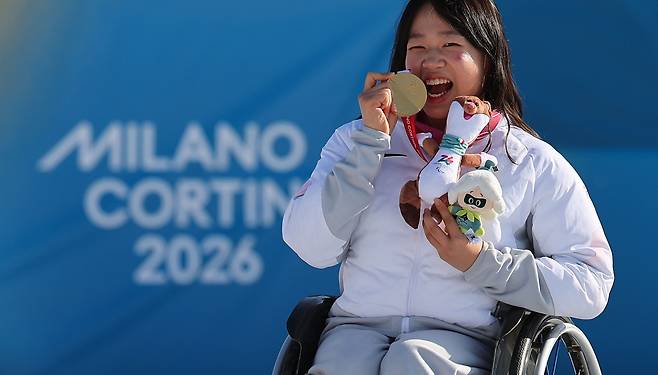 김윤지 선수가 8일(현지시간) 이탈리아 테세로 크로스컨트리 스타디움에서 열린 2026 밀라노·코르티나 동계 패럴림픽 파라 바이애슬론 여자 스프린트 좌식 12.5㎞ 시상식에서 금메달을 목에 걸고 기뻐하고 있다.  [연합]