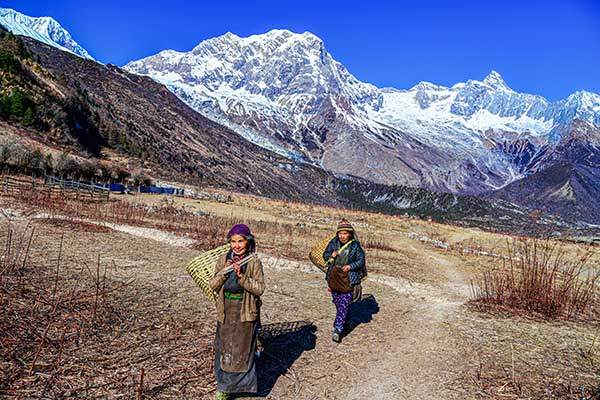 사마가온 마을 사람들 뒤로 나이크피크(6,211m)가 보인다.