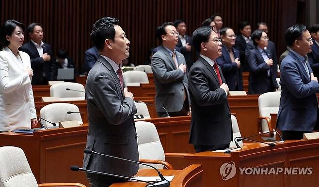 국민의힘 긴급 의원총회 (서울=연합뉴스) 이동해 기자 = 장동혁 대표와 송언석 원내대표를 비롯한 국민의힘 의원들이 9일 국회에서 열린 긴급 의원총회에서 국기에 경례하고 있다. 2026.3.9 eastsea@yna.co.kr