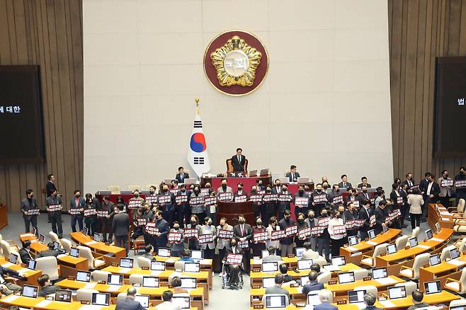 Lawmakers of the People Power Party hold placards in protest against the ruling Democratic Party’s three judicial reform bills during a plenary session of the 432nd National Assembly (extraordinary session) at the National Assembly in Yeouido, Seoul, on Feb. 28, The related bills were later passed. [NEWS1]