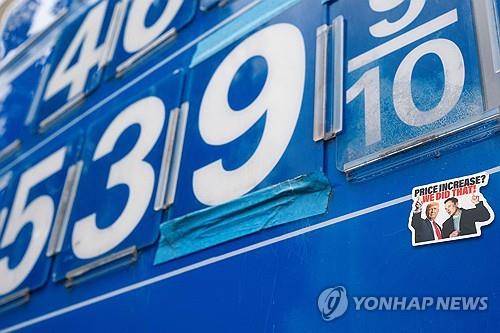 미국 주유소 휘발유 가격 (워싱턴DC 로이터=연합뉴스) 2026년 3월 8일 미국 수도 워싱턴DC소재 연방의회 의사당 근처 한 주유소에 있는 휘발유 가격 표시 간판에 도널드 트럼프 대통령과 일론 머스크 테슬라 CEO의 사진이 있는 스티커가 붙어 있다. (REUTERS/Nathan Howard/File Photo) 2026.3.10.