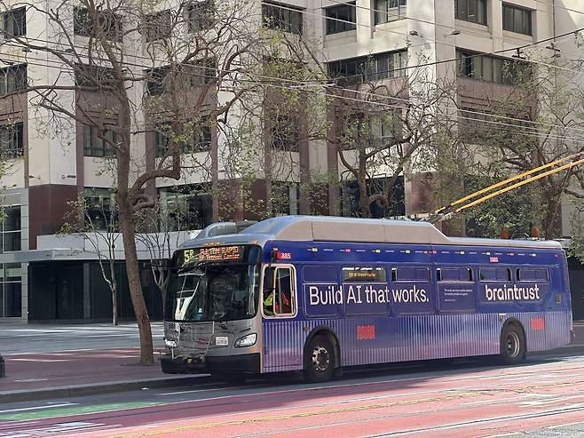 미국 샌프란시스코 도심을 달리는 버스 외벽에는 ‘Build AI that works(실제로 작동하는 AI를 만들어라)’라는 문구가 적힌 광고가 붙어 있었다. AI 인재 채용 플랫폼 ‘브레인트러스트(Braintrust)’의 광고다. 도시 곳곳에서 AI 기업들의 존재감을 확인할 수 있었다.(샌프란시스코(미국)=이수진 기자)