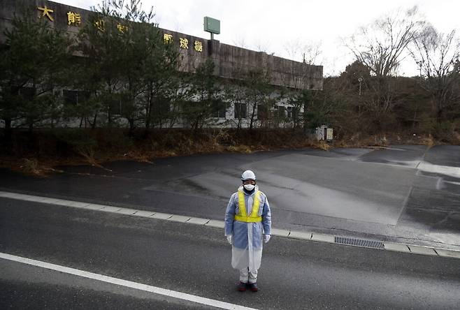 지난 4일 일본 후쿠시마 도로에 한 경비원이 서 있다. 후쿠시마/EPA 연합뉴스