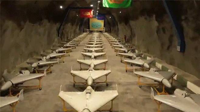 Footage released by the Iranian state-affiliated Fars news agency reveals rows of drones stored in underground tunnels and mounted on rocket launchers with walls adorned by Iranian flags. [SCREEN CAPTURE]