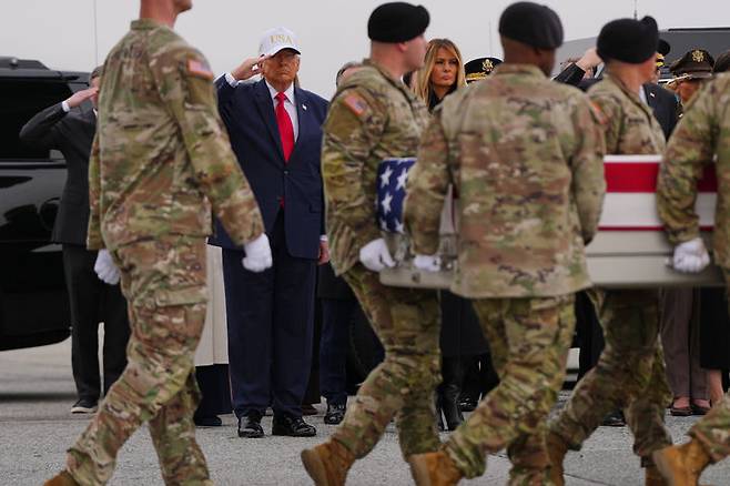 [도버 공군기지(델라웨어)=AP/뉴시스] 도널드 트럼프 미국 대통령이 7일(현지 시간) 델라웨어주 도버 공군기지에서 열린 시신 인도식(Dignified Transfer)에서 이란과의 군사 충돌로 쿠웨이트에서 전사한 미군의 유해가 담긴 성조기 덮인 운반함이 이동하는 동안 경례하고 있다. 2026.03.11.