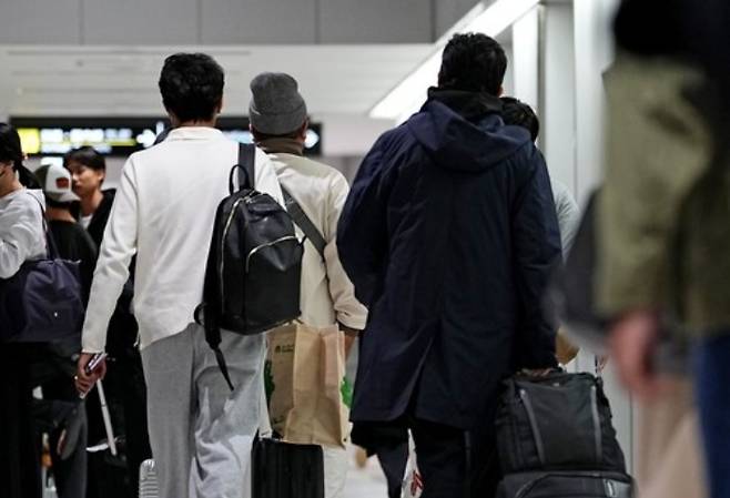 일본 정부가 중동에서 발이 묶인 자국민의 본국 귀환을 지원하기 위해 투입한 전세기편을 타고 도쿄 나리타공항에 도착한 사람들이 이동하는 모습. 연합뉴스