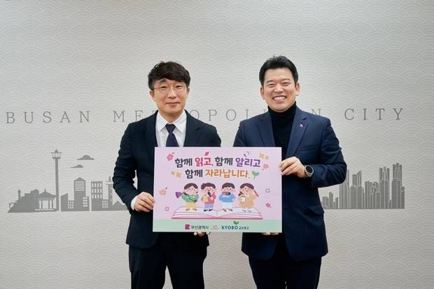 원영일(오른쪽) 부산시 대변인과 권윤호 교보문고 남부사업단장이 10일 시청에서 ‘시정 매체 홍보 및 어린이기자단 지원’ 협약을 맺고 기념촬영을 하고 있다. 사진제공=부산시