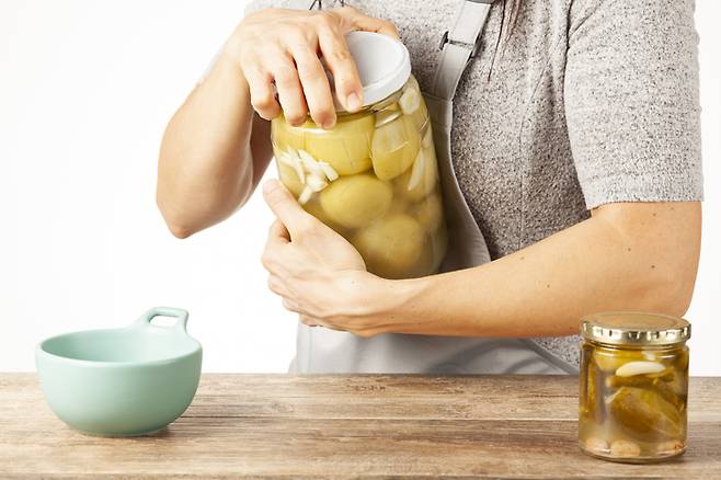 숟가락 손잡이 끝으로 병과 뚜껑 사이의 테두리에 넣으면 진공 상태가 해제되면서 쉽게 병뚜껑을 열 수 있다. 사진=게티이미지뱅크