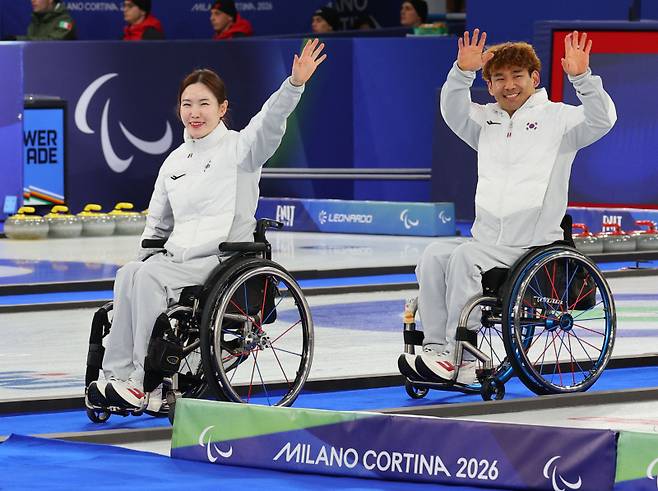 11일(현지시간) 이탈리아 코르티나 컬링 올림픽 스타디움에서 열린 2026 밀라노·코르티나담페초 동계 패럴림픽 휠체어컬링 믹스더블 시상식에서 은메달을 차지한 이용석과 백혜진이 입장하며 인사하고 있다. 연합뉴스&nbsp;&nbsp;