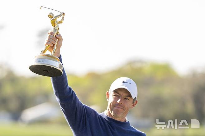 [폰테베드라비치=AP/뉴시스] 로리 매킬로이(북아일랜드)가 17일(현지 시간) 미 플로리다주 폰테베드라비치 TPC 소그래스에서 열린 미국프로골프(PGA) 투어 플레이어스 챔피언십 정상에 올라 트로피를 들고 포즈를 취하고 있다. 매킬로이는 최종 합계 12언더파 276타로 JJ 스펀(미국)과 동타를 이뤄 연장 끝에 우승을 차지했다. 2025.03.18.