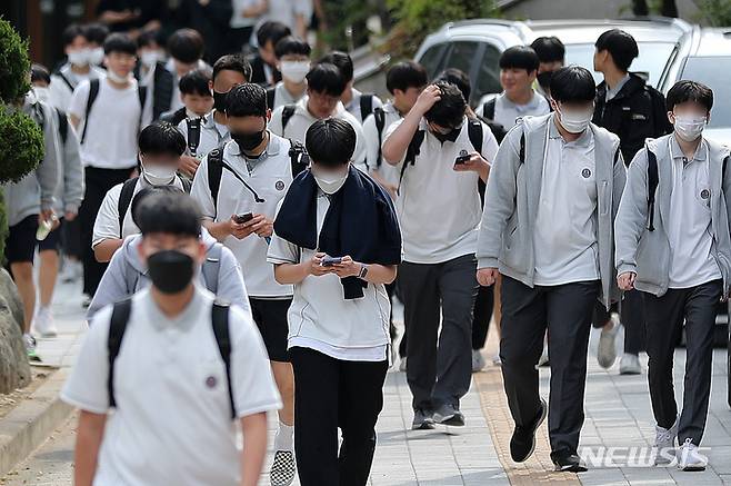[서울=뉴시스] 백동현 기자 = 지난 2022년 5월 25일 오후 서울 시내 한 중학교 앞에서 학생들이 스마트폰을 보면서 하교하고 있다. 해당 기사와 관계 없음. 2022.05.25. livertrent@newsis.com