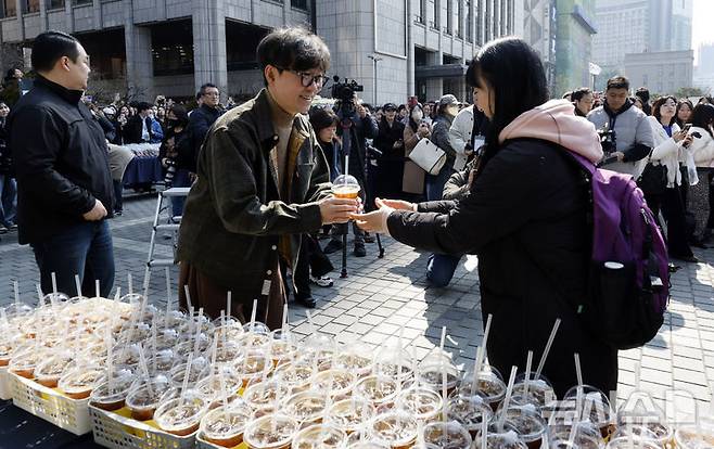 [서울=뉴시스] 김혜진 기자 = '천만 감독' 장항준 감독이 12일 오후 서울 중구 프레스센터 앞 광장에서 영화 '왕과 사는 남자' 흥행 감사 커피차 이벤트를 진행하고 있다. '왕과 사는 남자'는 개봉 36일째인 어제(11일) 관객수 1200만명을 넘어섰다. 이로써 '파묘'(1191만4869명)를 꺾고 역대 박스오피스 20위에 안착했다. 2026.03.12. jini@newsis.com