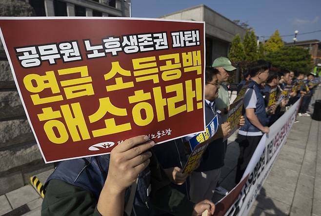 공무원 정년은 60세지만 연금지급 개시연령이 65세로 단계적으로 늦춰지면서 소득 공백 문제가 대두되고 있다. 사진은 전국공무원노동조합 조합원들이 서울 종로구 헌법재판소 앞에서 진행한 '공무원 노후생존권 연금소득공백 해소를 위한 권리구제 헌법소원청구' 기자회견 모습. / 뉴시스