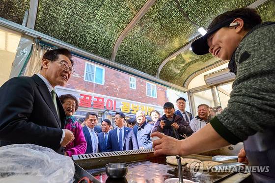 이재명 대통령이 13일 충북 청주시 서원구 사창시장을 찾아 상인과 인사를 하고 있다. 〈사진=청와대 제공 / 연합뉴스〉