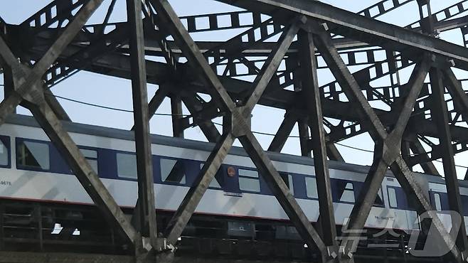 13일 오전 10시 단둥역을 출발한 국제 여객 열차가 압록강철교를 지나고 있다. 파란색 열차는 전일 오후 베이징에서 출발한 열차다. 2026.3.13