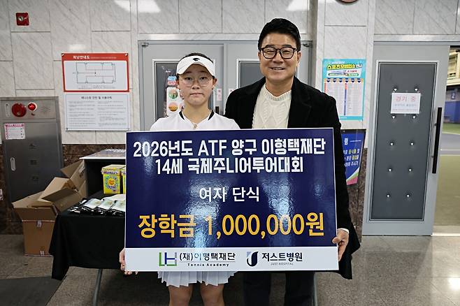 2차 대회 여자단식에서 우승하며 장학금 1백만원을 받은 김서현과 이형택 이사장(오른쪽)