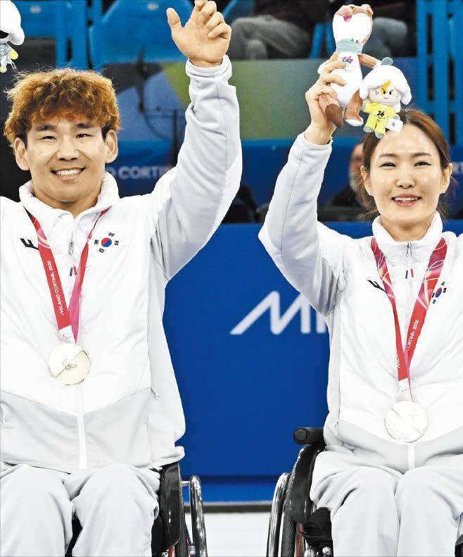 밀라노 코르티나 동계 패럴림픽 휠체어 컬링 믹스더블에서 은메달을 딴 이용석(왼쪽)과 백혜진이 손을 들어 인사하고 있다./사진공동취재단