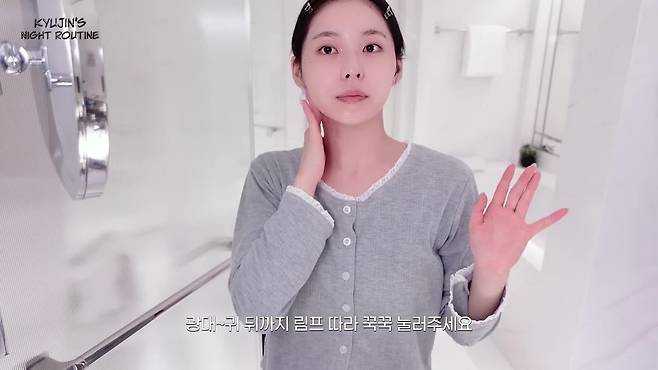 세럼을 바른 후 가볍게 손으로 림프 마사지를 하면 부기를 완화해 준다. 유튜브 〈NMIXX〉