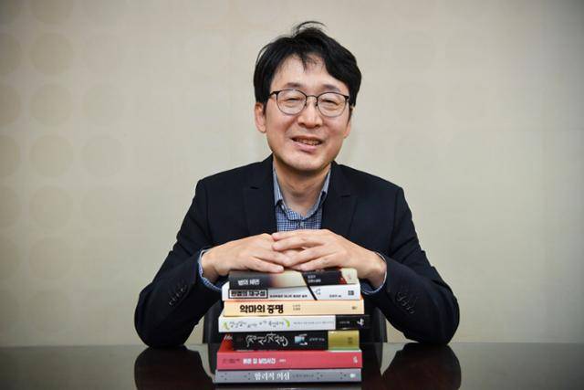 법관 출신 도진기 작가가 판사 재직 시절부터 펴냈던 책 일부와 함께 웃고 있다. 그는 "나이 마흔이 되어서야 다시 추리소설을 읽기 시작했다. 글을 쓰게 된 계기다"고 말했다. 윤기훈 인턴기자