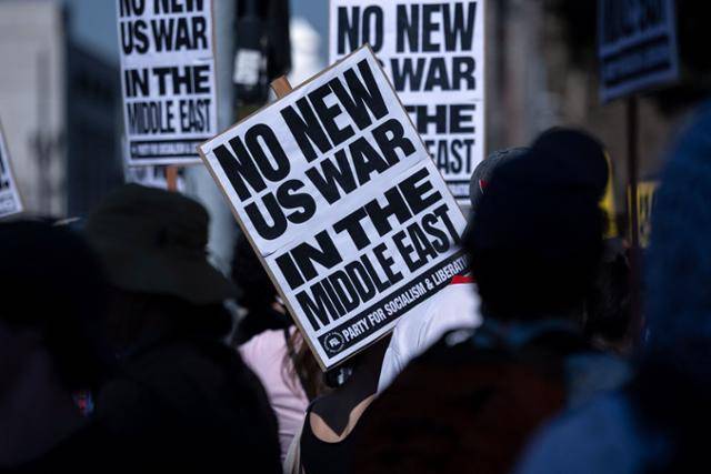 미국과 이스라엘이 이란을 공습한 지난달 전쟁 반대 시위가 열린 미 캘리포니아주 로스앤젤레스 시청 앞에서 집회 참가자들이 “중동에서 새로운 전쟁을 벌이면 안 된다“라고 적힌 피켓을 들고 있다. 로스앤젤레스=AFP 연합뉴스