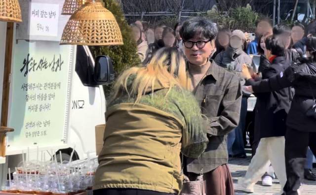 ▲ 영화 ‘왕과 사는 남자’의 장항준 감독이 12일 서울 중구 한국프레스센터 앞에서 ‘커피차 이벤트’를 열고, 팬들에게 커피를 나눠주고 있다.  이세훈 기자