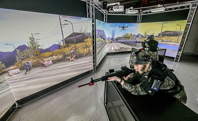 Trainees take part in VR training in front of a three-panel screen at the Seocho Reserve Training Center in southern Seoul. (Republic of Korea Army)