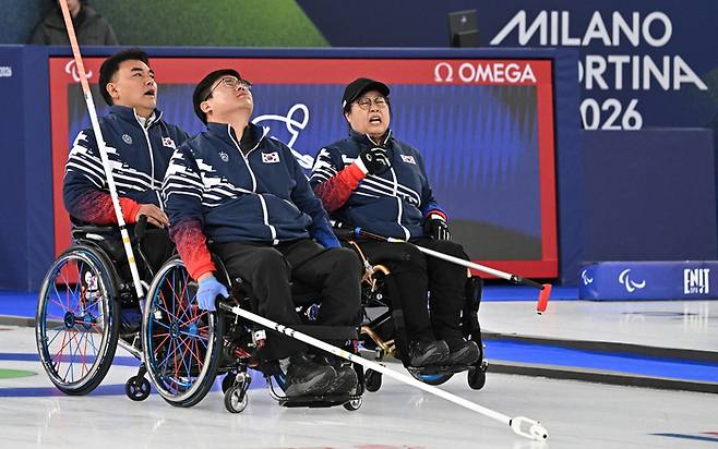 휠체어컬링 차진호, 이현출, 방민자(왼쪽부터)가 13일(현지시간) 이탈리아 코르티나담페초 컬링 올림픽 스타디움에서 열린  2026 밀라노 코르티나 패럴림픽 휠체어컬링 혼성 4인조 캐나다와의 준결승전에서 패하며 아쉬워하고 있다. 사진 | 코르티나=사진공동취재단